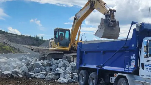 Camion de vrac qui se fait charger par une pelle mécanique